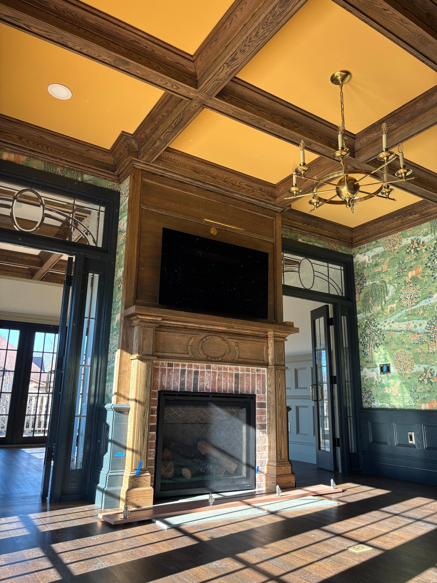 Great room with a coffered ceiling, fireplace, and flanking built-ins