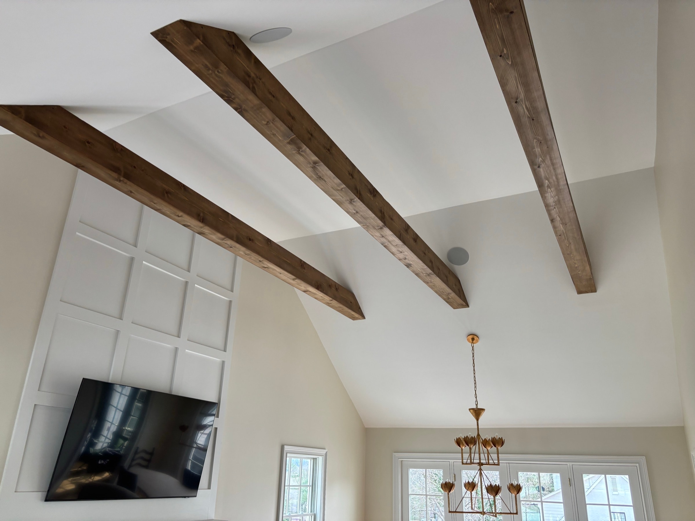Vaulted great room with dark stained box beams across the ceiling, installed by Dunn Trim Co.