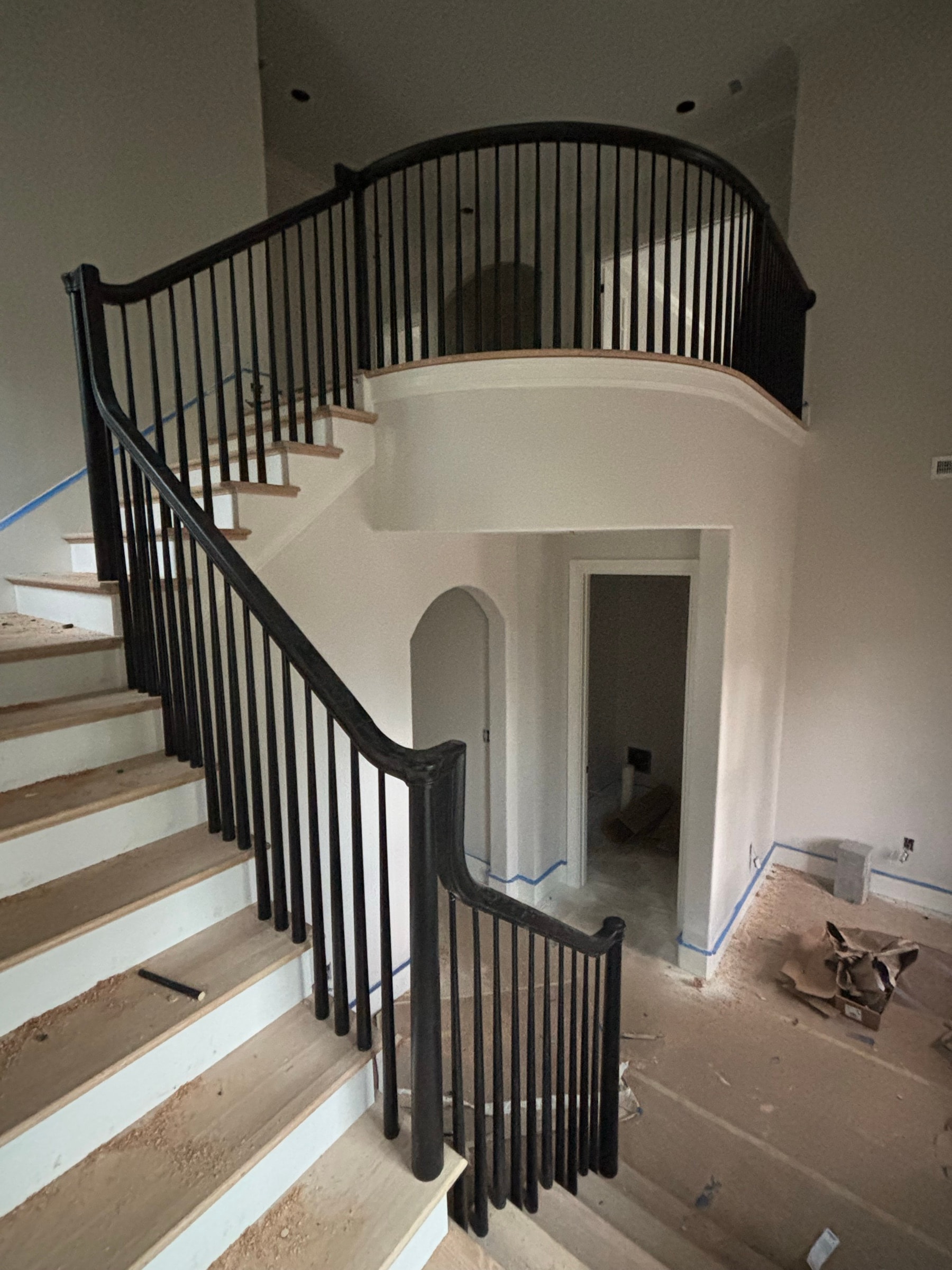 Grand curved staircase with wood treads and a sweeping handrail