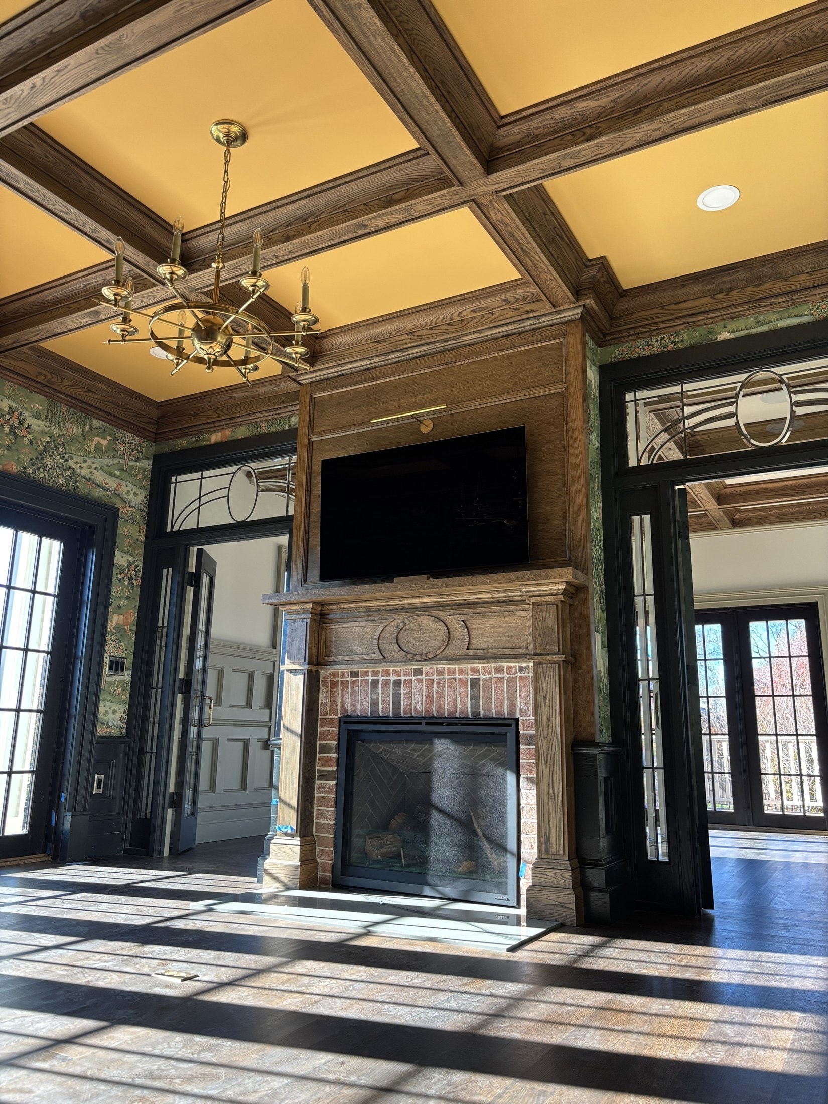 Coffered ceiling and floor-to-ceiling fireplace built-ins in a great room