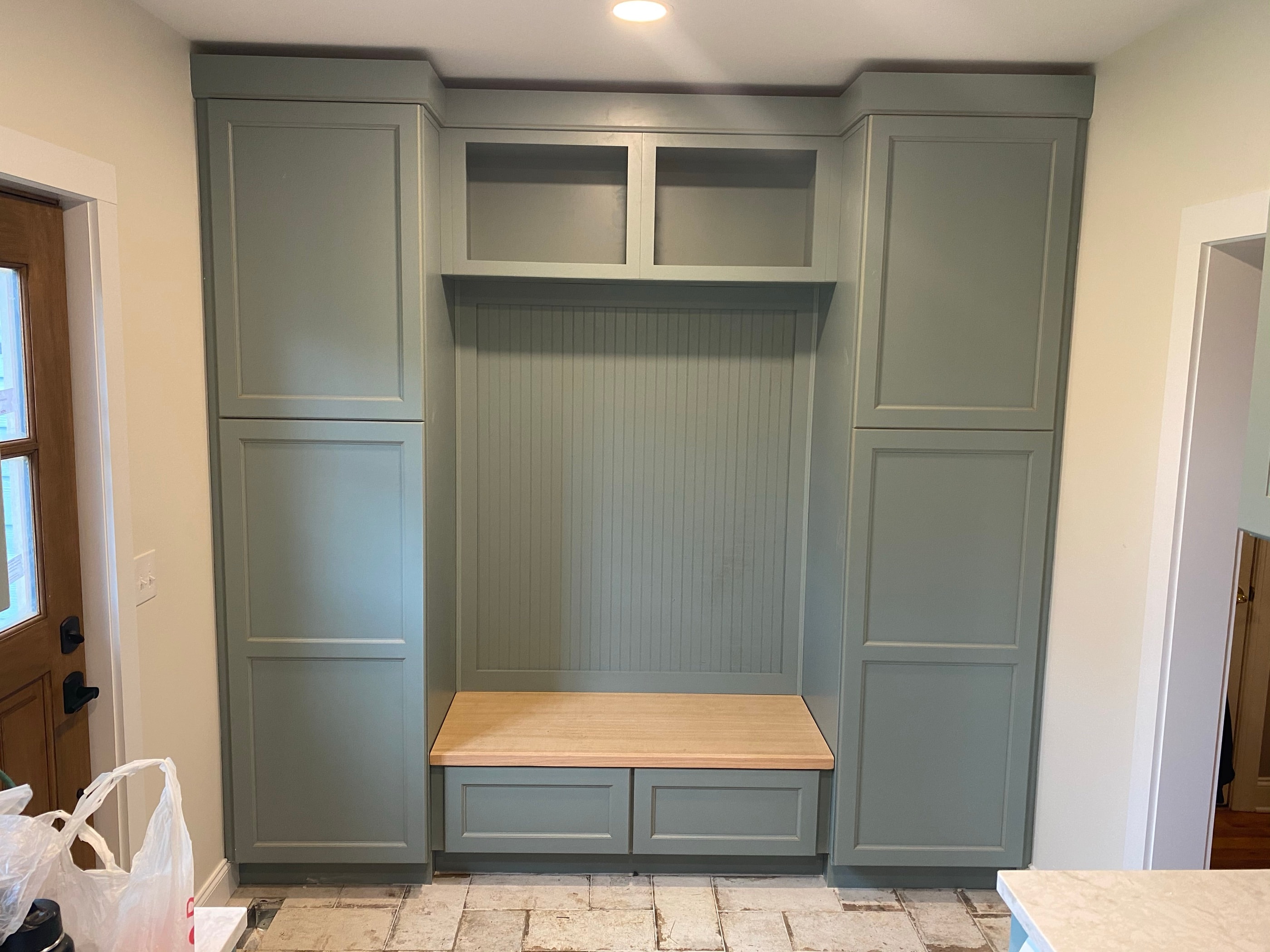 Sage-green mudroom built-in bench with cubbies and lockers