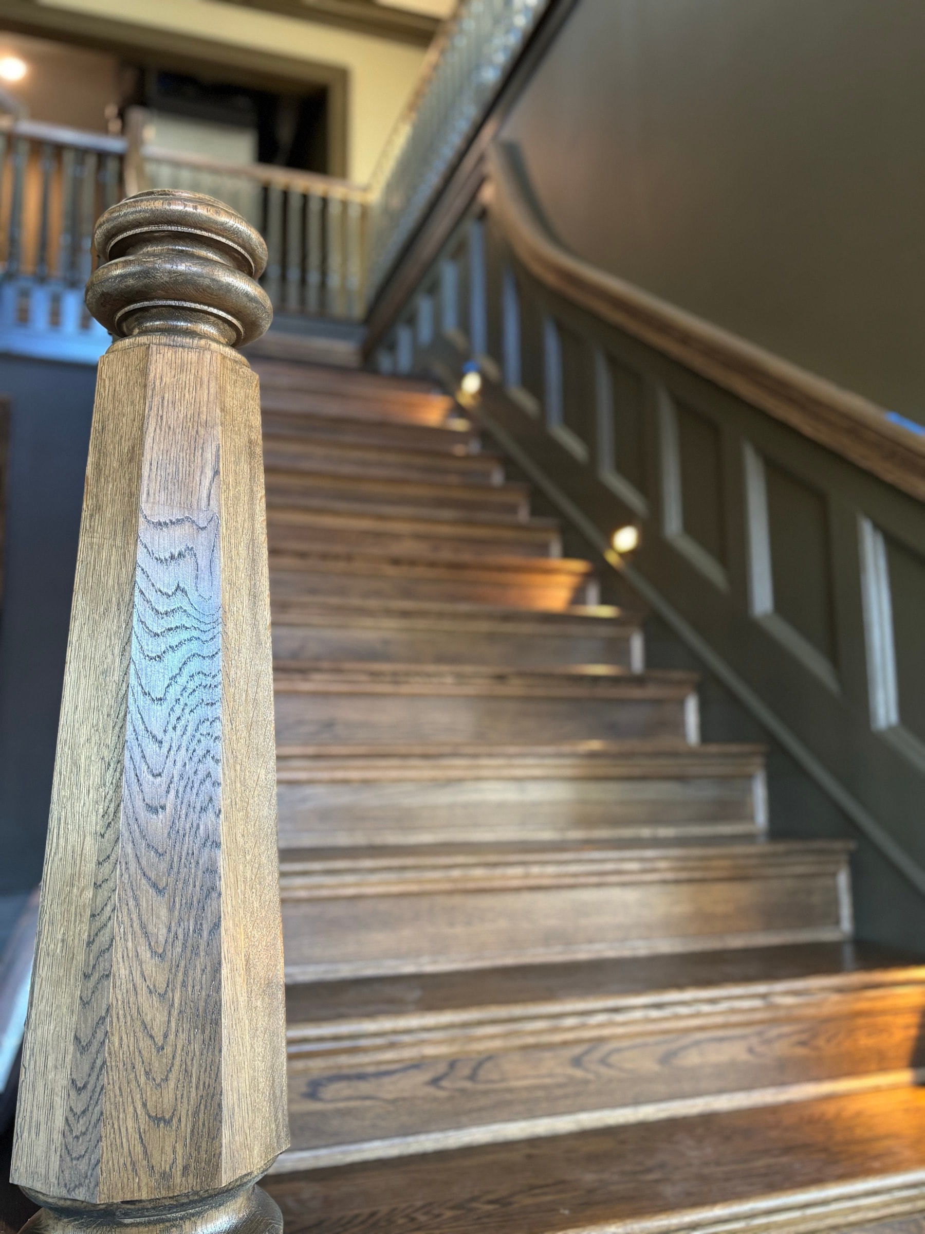 Staircase running alongside a paneled stair wall